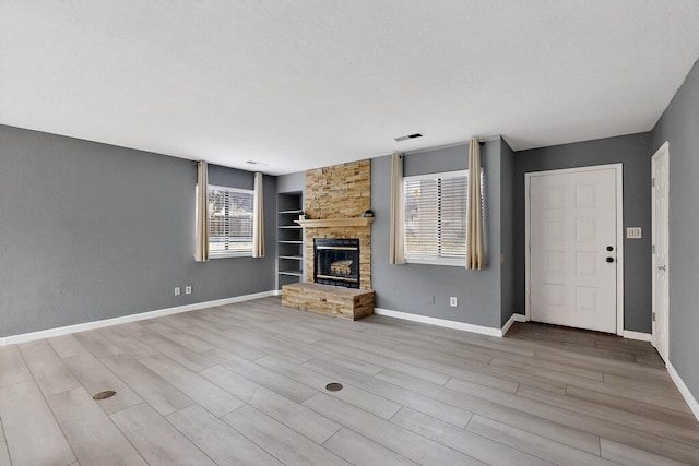 2900 Vista Del Rey NE Unit 7A, Albuquerque, NM 87112 - unfurnished living room with built in shelves, a large fireplace, and wood finished floors