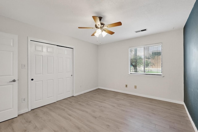 2900 Vista Del Rey NE Unit 7A, Albuquerque, NM 87112 - unfurnished bedroom featuring light wood-style floors, a closet, and a ceiling fan
