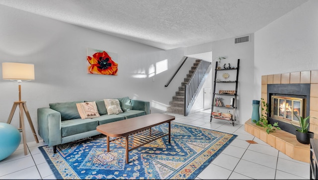 6041 Sequoia Rd NW Unit B3, Albuquerque, NM 87120 - tiled living room featuring stairs, a textured ceiling, and a tile fireplace