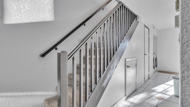 6041 Sequoia Rd NW Unit B3, Albuquerque, NM 87120 - staircase with tile patterned floors, a textured wall, and washer / dryer