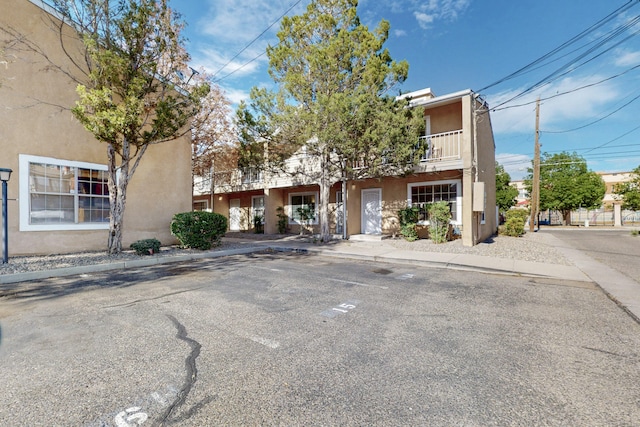700 Fruit Ave NW Unit G, Albuquerque, NM 87102 - view of front of home with stucco siding, uncovered parking, and a balcony