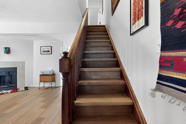 700 Fruit Ave NW Unit G, Albuquerque, NM 87102 - staircase with wood finished floors, a tile fireplace, and a textured ceiling