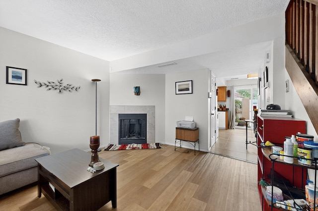 700 Fruit Ave NW Unit G, Albuquerque, NM 87102 - living room featuring a tile fireplace, light wood-style floors, and a textured ceiling
