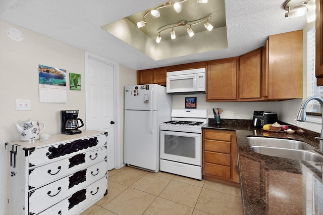 700 Fruit Ave NW Unit G, Albuquerque, NM 87102 - kitchen featuring white appliances, a tray ceiling, brown cabinets, light tile patterned flooring, and dark stone counters