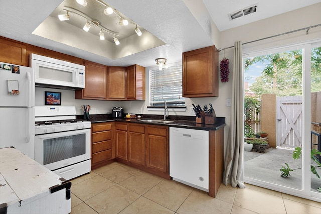 700 Fruit Ave NW Unit G, Albuquerque, NM 87102 - kitchen featuring white appliances, a raised ceiling, brown cabinetry, and light tile patterned flooring