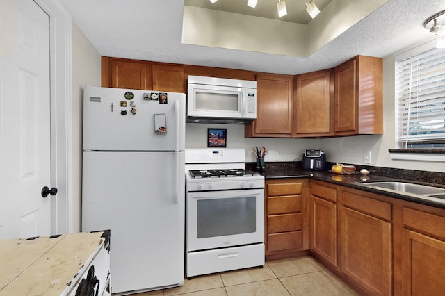 700 Fruit Ave NW Unit G, Albuquerque, NM 87102 - kitchen with white appliances, brown cabinetry, and light tile patterned flooring