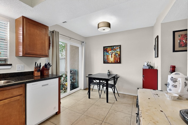 700 Fruit Ave NW Unit G, Albuquerque, NM 87102 - kitchen featuring dishwasher, brown cabinetry, light tile patterned floors, a textured ceiling, and dark countertops