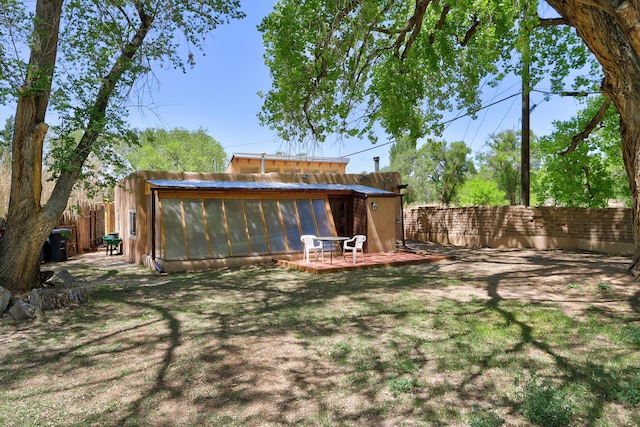541 Atrisco Dr NW, Albuquerque, NM 87105 - fenced backyard featuring a sunroom and a wooden deck