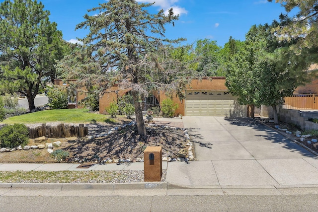 13101 Comanche Rd NE, Albuquerque, NM 87111 - view of property hidden behind natural elements featuring concrete driveway and a garage