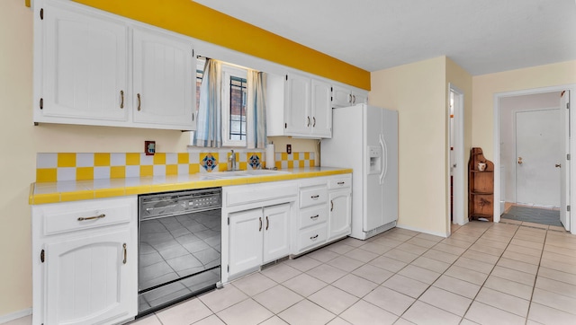 13101 Comanche Rd NE, Albuquerque, NM 87111 - kitchen with black dishwasher, white refrigerator with ice dispenser, tile countertops, and white cabinetry
