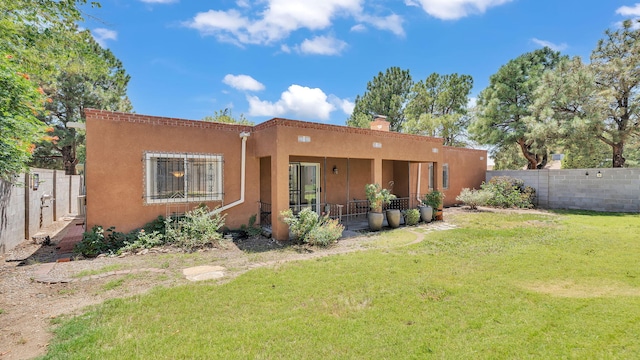 13101 Comanche Rd NE, Albuquerque, NM 87111 - rear view of house with stucco siding, a fenced backyard, and a chimney