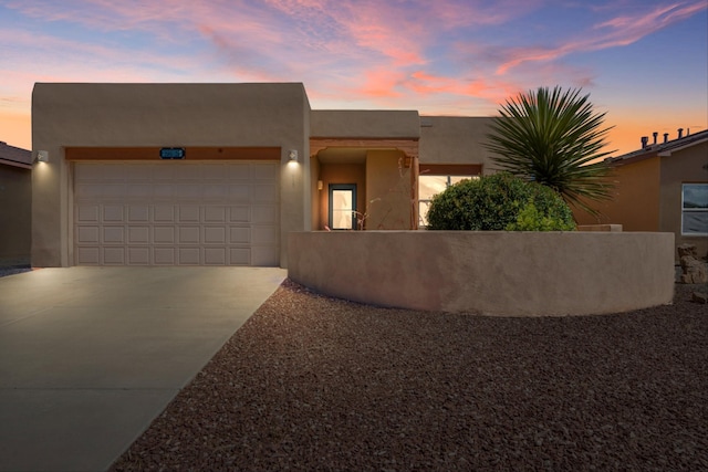 6615 Mountain Hawk Loop NE, Rio Rancho, NM 87144 - adobe home with concrete driveway, stucco siding, and a garage