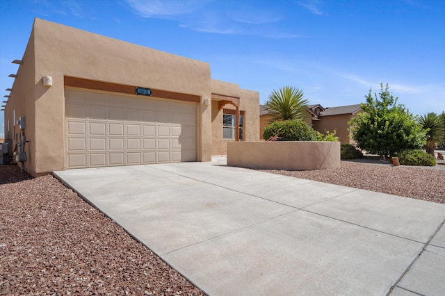 6615 Mountain Hawk Loop NE, Rio Rancho, NM 87144 - pueblo-style house with driveway, stucco siding, and an attached garage
