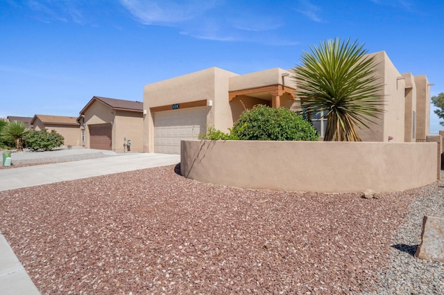 6615 Mountain Hawk Loop NE, Rio Rancho, NM 87144 - pueblo-style home featuring stucco siding, a garage, and driveway