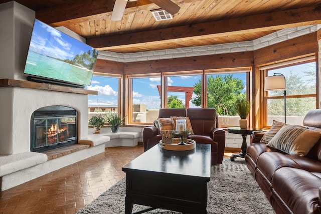 1524 W Meadowlark Ln, Corrales, NM 87048 - living room with a wood ceiling with exposed beams, a ceiling fan, a glass covered fireplace, and brick flooring