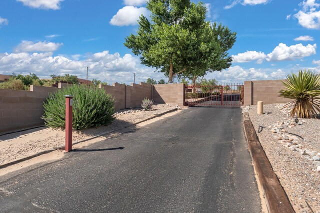 1524 W Meadowlark Ln, Corrales, NM 87048 - view of asphalt road featuring curbs, a gate, and a gated entry