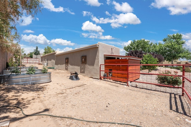 1524 W Meadowlark Ln, Corrales, NM 87048 - back of property with a vegetable garden, stucco siding, and an exterior structure