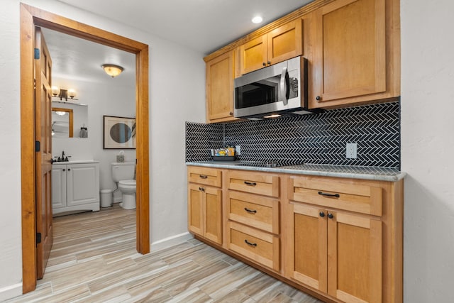 1524 W Meadowlark Ln, Corrales, NM 87048 - kitchen with stainless steel microwave, backsplash, light wood-style floors, and light countertops