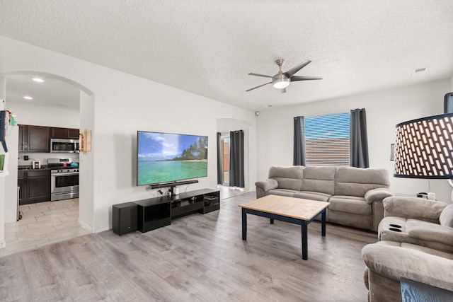 9909 Saddlehorn Trl SW, Albuquerque, NM 87121 - living area with arched walkways, ceiling fan, a textured ceiling, light wood-style floors, and recessed lighting