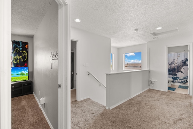 9909 Saddlehorn Trl SW, Albuquerque, NM 87121 - hallway with a textured ceiling, carpet, an upstairs landing, and attic access