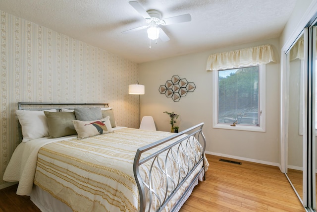 13527 Cedarbrook Ave NE, Albuquerque, NM 87111 - bedroom with wood-type flooring, a textured ceiling, a closet, and a ceiling fan