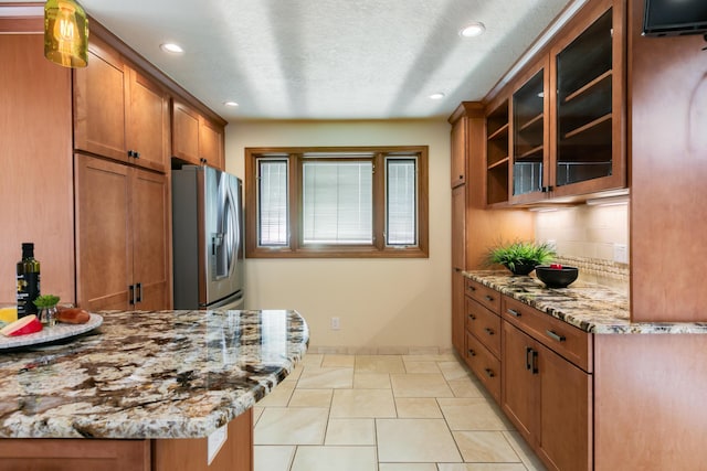13527 Cedarbrook Ave NE, Albuquerque, NM 87111 - kitchen featuring stainless steel fridge, brown cabinets, recessed lighting, decorative backsplash, and glass insert cabinets