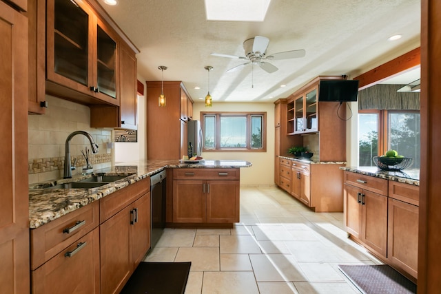 13527 Cedarbrook Ave NE, Albuquerque, NM 87111 - kitchen with a peninsula, stainless steel appliances, brown cabinets, tasteful backsplash, and stone counters