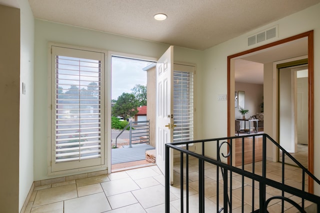 13527 Cedarbrook Ave NE, Albuquerque, NM 87111 - doorway to outside featuring a textured ceiling and light tile patterned flooring