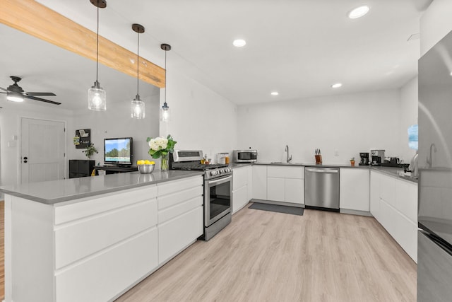 11608 Clifford Ave NE, Albuquerque, NM 87112 - kitchen with appliances with stainless steel finishes, a peninsula, light wood-style floors, white cabinetry, and recessed lighting