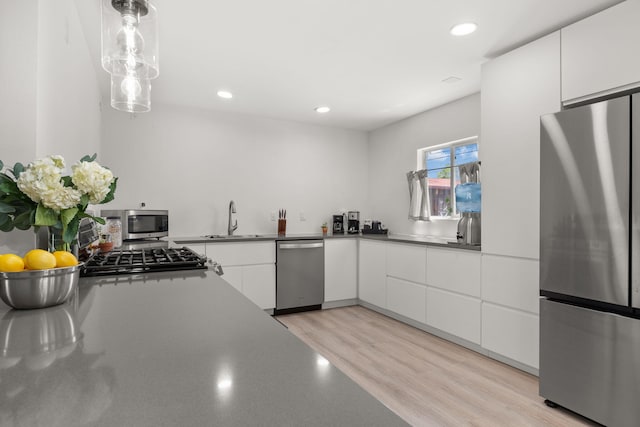 11608 Clifford Ave NE, Albuquerque, NM 87112 - kitchen featuring appliances with stainless steel finishes, white cabinets, recessed lighting, decorative light fixtures, and light wood-type flooring