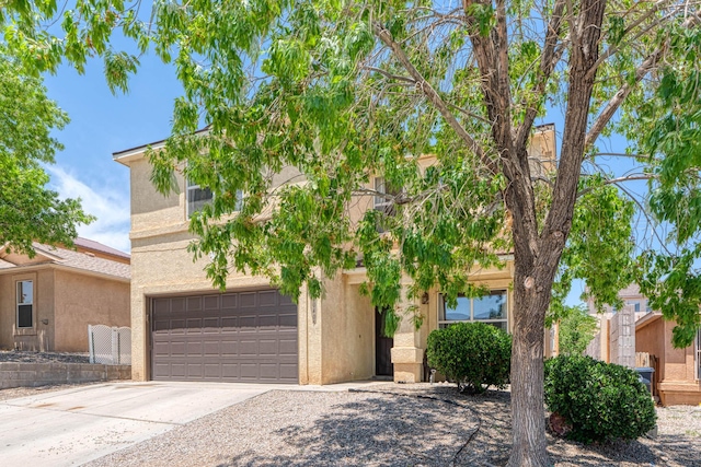 10405 Red Robin Rd SW, Albuquerque, NM 87121 - view of property hidden behind natural elements with concrete driveway, stucco siding, and an attached garage