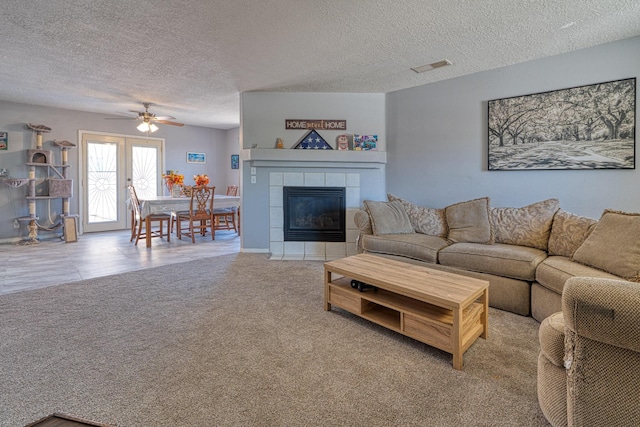 10405 Red Robin Rd SW, Albuquerque, NM 87121 - carpeted living area featuring a ceiling fan, a textured ceiling, and a tiled fireplace