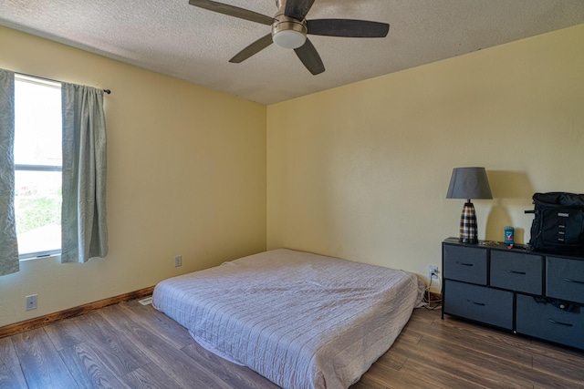 10405 Red Robin Rd SW, Albuquerque, NM 87121 - bedroom with multiple windows, dark wood-style flooring, a textured ceiling, and ceiling fan