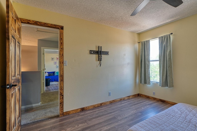 10405 Red Robin Rd SW, Albuquerque, NM 87121 - unfurnished bedroom with a textured ceiling, multiple windows, wood finished floors, and a ceiling fan