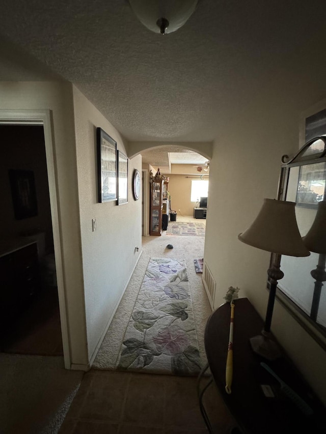 6356 Azaleas Rd NW, Albuquerque, NM 87114 - hallway featuring arched walkways, carpet flooring, and a textured ceiling