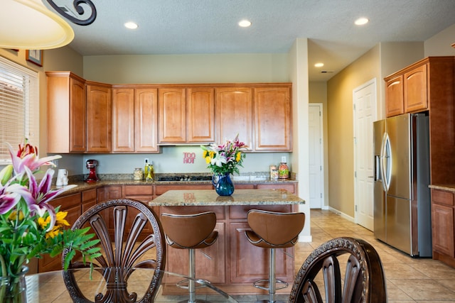 3726 Linda Vista Ave NE, Rio Rancho, NM 87124 - kitchen with stainless steel refrigerator with ice dispenser, a kitchen island, recessed lighting, light stone counters, and light tile patterned flooring