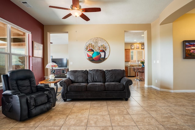 3726 Linda Vista Ave NE, Rio Rancho, NM 87124 - living area with ceiling fan, light tile patterned floors, and arched walkways