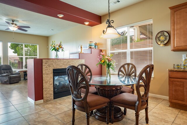 3726 Linda Vista Ave NE, Rio Rancho, NM 87124 - dining area with light tile patterned floors, a ceiling fan, and a multi sided fireplace