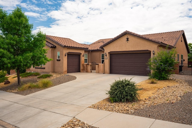 3726 Linda Vista Ave NE, Rio Rancho, NM 87124 - mediterranean / spanish home with an attached garage, a gate, a tiled roof, and driveway