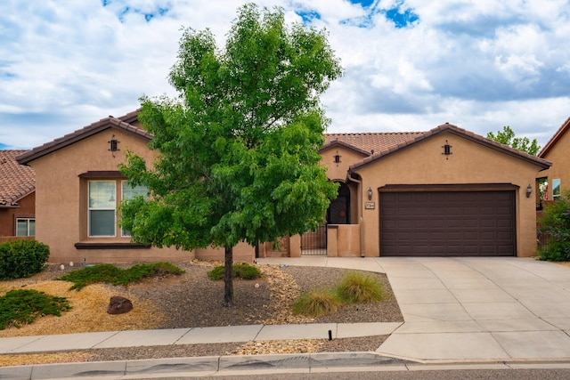 3726 Linda Vista Ave NE, Rio Rancho, NM 87124 - mediterranean / spanish-style house featuring driveway, an attached garage, a tiled roof, and stucco siding
