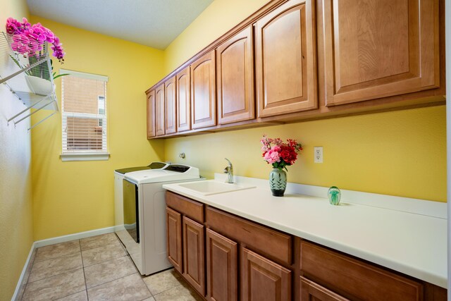 3726 Linda Vista Ave NE, Rio Rancho, NM 87124 - laundry area featuring washer and dryer, cabinet space, and light tile patterned flooring