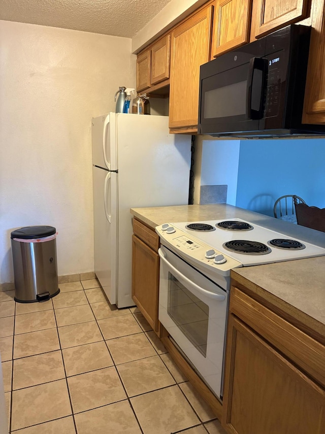 3847 Montgomery Blvd NE Unit 923, Albuquerque, NM 87109 - kitchen featuring white appliances, light tile patterned flooring, a textured ceiling, light countertops, and brown cabinetry