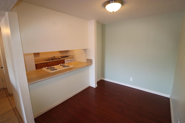 3847 Montgomery Blvd NE Unit 923, Albuquerque, NM 87109 - kitchen with white electric stovetop, wood finished floors, light countertops, and a textured ceiling