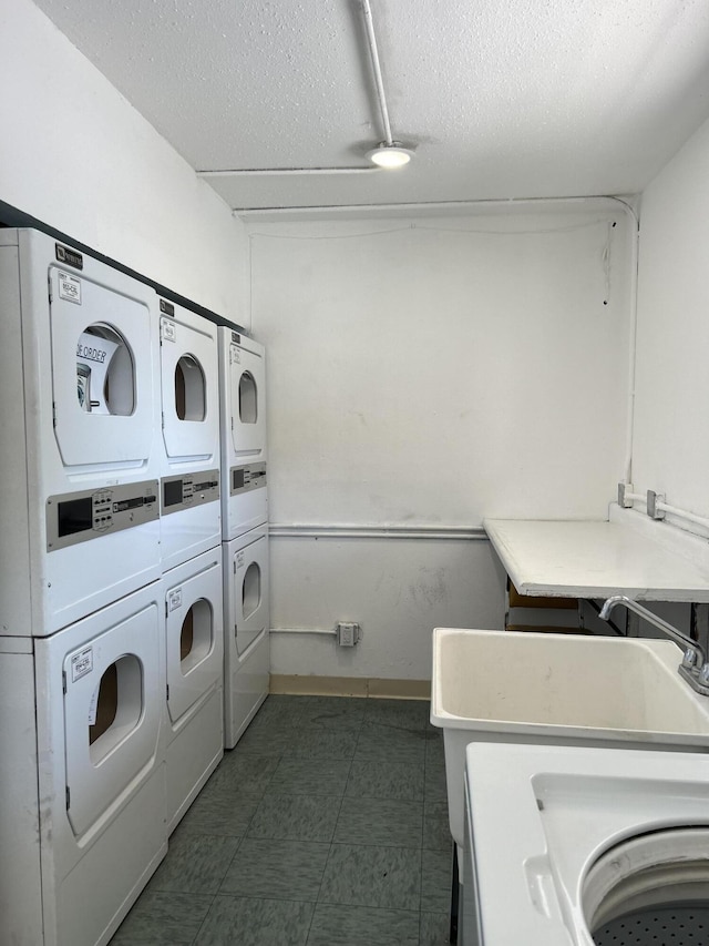 3847 Montgomery Blvd NE Unit 923, Albuquerque, NM 87109 - shared laundry featuring stacked washing machine and dryer, a textured ceiling, and independent washer and dryer
