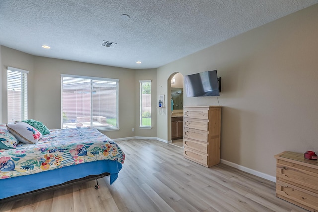 2952 Kings Canyon Loop NE, Rio Rancho, NM 87144 - bedroom featuring arched walkways, light wood-type flooring, a textured ceiling, and recessed lighting