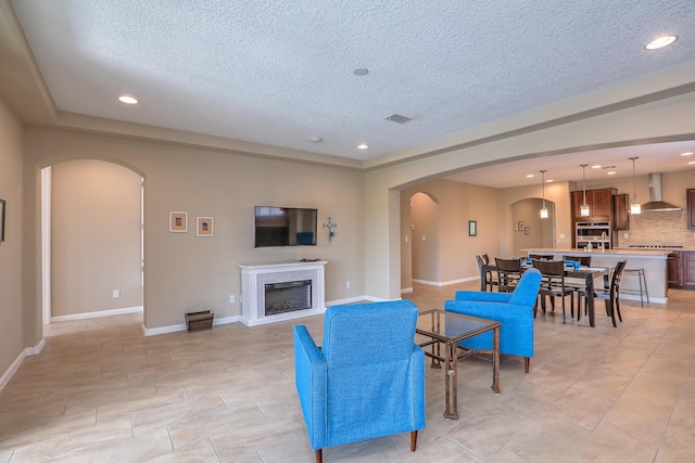 2952 Kings Canyon Loop NE, Rio Rancho, NM 87144 - living area with arched walkways, a textured ceiling, a fireplace, and recessed lighting