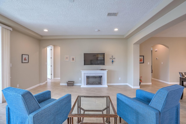 2952 Kings Canyon Loop NE, Rio Rancho, NM 87144 - living area featuring arched walkways, a textured ceiling, recessed lighting, and a fireplace