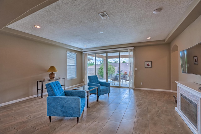 2952 Kings Canyon Loop NE, Rio Rancho, NM 87144 - living area with a textured ceiling, recessed lighting, and a glass covered fireplace