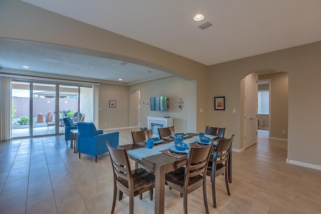 2952 Kings Canyon Loop NE, Rio Rancho, NM 87144 - dining space featuring arched walkways, recessed lighting, and a fireplace