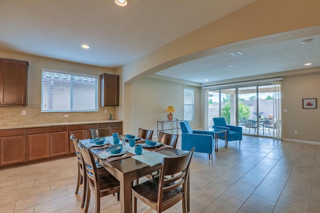 2952 Kings Canyon Loop NE, Rio Rancho, NM 87144 - dining area featuring arched walkways, recessed lighting, a textured ceiling, and light tile patterned floors